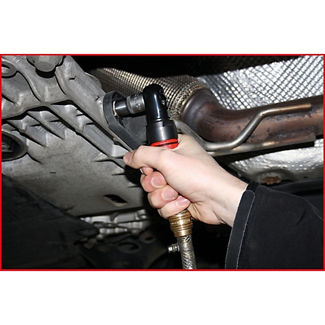 Eine Hand hält einen Druckluftschrauber und schraubt an einem Fahrzeugteil. Der Schrauber hat eine rote Umrandung.